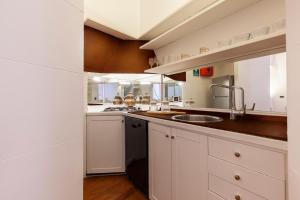 una cucina con mobili bianchi e un lavandino di Navona Historic Luxury Deluxe a Roma
