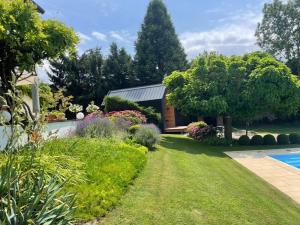 a garden with a house and a swimming pool at LA MAISON UGOLIN Tiny House and INÈS in Baccarat