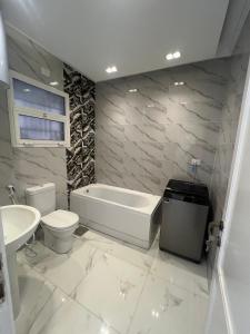 MadinatyProperty Sisters, Elite new home, Madinaty B11的带浴缸、马桶和水槽的浴室 更多15张照片