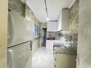 MadinatyProperty Sisters, Elite new home, Madinaty B11的白色的厨房配有冰箱和水槽