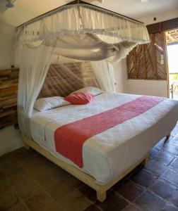 a bedroom with a bed with a canopy at Casa de la Gente Nube in Puerto Escondido