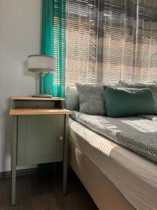 a bed with a table next to a window at Guest House Malusha in Gabrovo