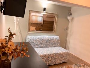 a living room with a chair and a mirror at Guest House Malusha in Gabrovo