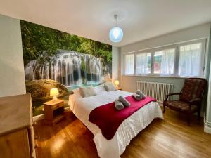 une chambre avec une fresque murale en forme de cascade sur le mur dans l'établissement La Tour du Lac, gîte bel & spacieux à côté du lac de Gerardmer, à Gérardmer