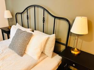 a bedroom with a bed with pillows and two lamps at Guest House Malusha in Gabrovo