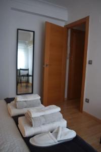 a pile of towels sitting on a bed in front of a mirror at Inmejorable Apartamento cerca Estación Delicias con GARAJE in Zaragoza