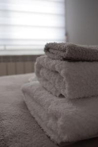 a pile of towels sitting on top of a bed at Inmejorable Apartamento cerca Estación Delicias con GARAJE in Zaragoza
