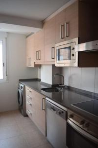 a kitchen with a sink and a microwave at Inmejorable Apartamento cerca Estación Delicias con GARAJE in Zaragoza
