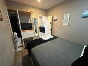 a small bedroom with a bed and a television at Stay549 in Winnipeg +61 photos