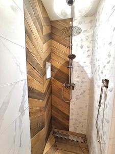 a bathroom with a shower with wood paneling at Duplex Trespoey - SPA - Place de parking in Pau