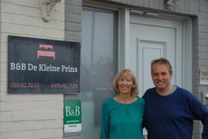 un hombre y una mujer parados frente a un edificio en B&B De Kleine Prins, en Middelkerke