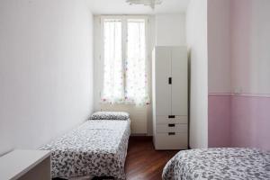 a small bedroom with two beds and a window at Bologna's Heart at Farini 31 in Bologna