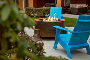 two blue chairs and a fountain in a yard at Courtyard Seattle North / Lynnwood Everett in Lynnwood
