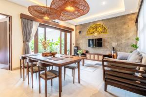 ヌサドゥアにあるTaman Dharmawangsa Villa - 3BR Luxury Private Pool Villa in Nusa Duaの木製のテーブルと椅子のあるダイニングルーム