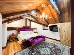 una camera con un letto viola e un divano viola di Hotel & Rooftop King Experience by David a Quito