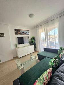 a living room with a couch and a tv at Apartament Carina in Mar de Cristal