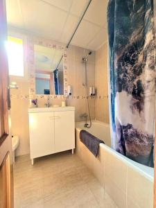 a bathroom with a tub and a sink and a shower at Apartament Carina in Mar de Cristal