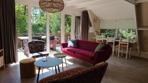 a living room with a red couch and a table at Bungalow Durbuy in Durbuy