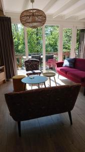 a living room with a couch and two tables at Bungalow Durbuy in Durbuy