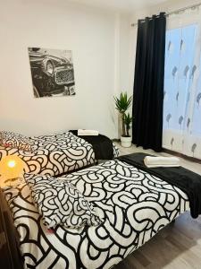 a bedroom with two beds with black and white sheets at Duplex TH Sanse Norte in San Sebastián de los Reyes