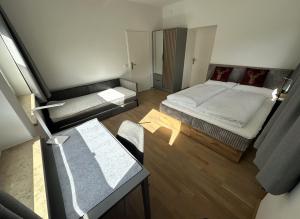 a small room with two beds and a table at DAS LUDWIG - Haus HOCHLAND in Garmisch-Partenkirchen