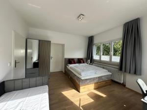 a bedroom with two beds and a large window at DAS LUDWIG - Haus HOCHLAND in Garmisch-Partenkirchen +150 photos