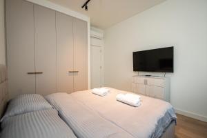 a bedroom with a bed and a flat screen tv at Belgrade Waterfront SCALA in Belgrade