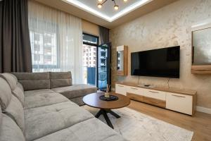 a living room with a couch and a flat screen tv at Belgrade Waterfront SCALA in Belgrade