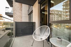 a balcony with a white chair and a table at Belgrade Waterfront SCALA in Belgrade