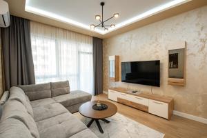 a living room with a couch and a flat screen tv at Belgrade Waterfront SCALA in Belgrade