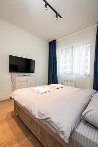 a bedroom with a large bed with a flat screen tv at Belgrade Waterfront SCALA in Belgrade
