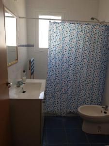a bathroom with a toilet and a shower curtain at Lo Conseguí in Bollullos de la Mitación