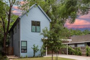 a blue house with a gambrel roof at Pristine Pool Palace 6BR - Rainey St - 7min walk in Austin
