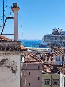 a tower on top of a building with a cruise ship in the background at Cozy flat with marvelous view in Lisbon