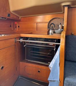 a kitchen with an oven with a sink and a table at Zeiljacht op Urk, Nederland in Urk