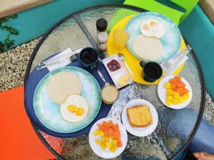 a glass table topped with plates of eggs and fruit at Hotel La Caracola Salento in Salento +95 photos