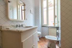 a bathroom with a sink and a toilet and a mirror at Terrazza Minerva in Rome +24 photos