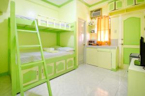 a room with two bunk beds and a kitchen at Bambooze Hauz in Boracay
