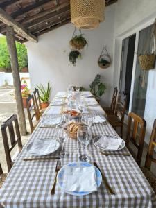 a long table with plates and wine glasses on it at Casa do Camondo in Veiros +24 photos