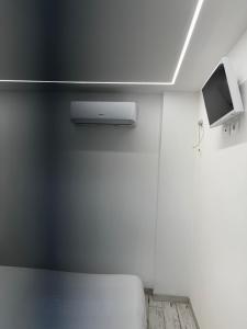 a white room with a bed and a tv at La conchiglia di susy in Capoliveri