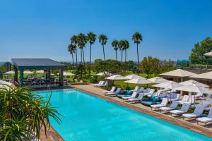 a pool with lounge chairs and umbrellas at a resort at VEA Newport Beach, a Marriott Resort & Spa in Newport Beach