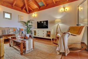 un soggiorno con un divano e una TV di Villa Charly a Puerto de la Madera