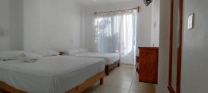 two beds in a room with a window and a room with two beds at Yuu-Lee Casa Bendita Huatulco in Santa Cruz Huatulco +11 photos