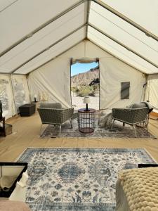 a tent with chairs and a table and a rug at Vegas Glamping in Marie Camp