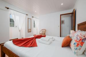 Un dormitorio con una cama blanca con una manta roja. en Casa Mar, en Ponta Delgada