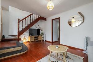 Una sala de estar con una escalera y un televisor. en Casa Mar, en Ponta Delgada