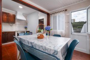 una cocina con una mesa con una cesta de flores. en Casa Mar, en Ponta Delgada
