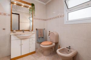 Un baño con inodoro, lavabo y espejo. en Casa Mar, en Ponta Delgada 20 fotos más