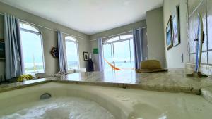 a large bath tub in a room with windows at Casa Grega in Governador Celso Ramos +80 photos