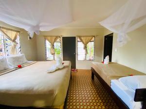 a bedroom with two beds with white sheets and windows at Maika beachside homestay in Nalauwaki